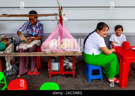 Une femme et un enfant assis à une table à la Street Food, Yangon, Myanmar. Banque D'Images