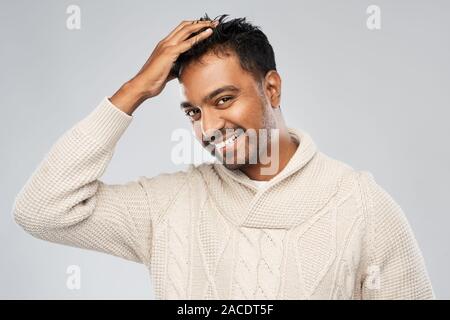 L'homme indien en chandail tricoté de toucher ses cheveux Banque D'Images