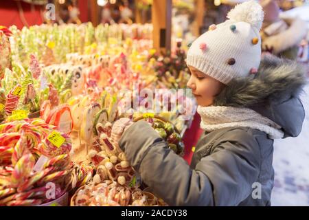 Petite fille de choisir des bonbons au marché de Noël Banque D'Images