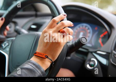 Concept de prise de vue : girl s mains sur le volant d'une voiture, un bracelet avec l'inscription dream sur sa main. Banque D'Images