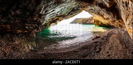 Vue panoramique exceptionnelle sur la mer de Seascape grotte surplombant au-dessus de l'eau sur la célèbre plage de Cala Bianca environs pittoresques. Les vagues d'eau de mer cristalline wa Banque D'Images