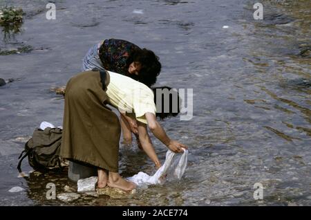 9 août 1993 pendant le siège de Sarajevo : les femmes laver la lessive dans la rivière Miljacka, juste en amont de la National Art Gallery et de la bibliothèque. Banque D'Images