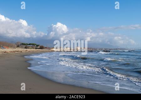 Plage de sable avec des vagues déferlantes. Marinella di Sarzana en direction de Marina di Carrara. La mer Méditerranée, l'Europe. Saison d'hiver. Banque D'Images