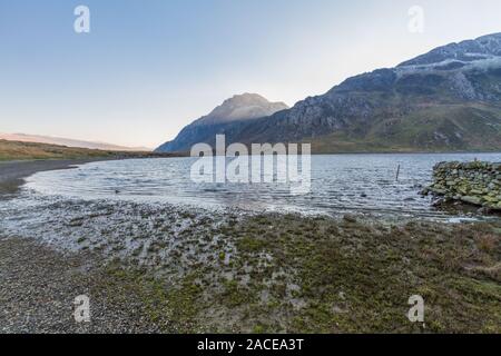 La lumière du matin sur le pic enneigé des rives du lac de Tryfan ou Llyn Idwal. Le parc national de Snowdonia, Gwynedd, Pays de Galles, Royaume-Uni. Paysage, grand angle. Banque D'Images