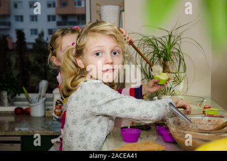 Les enfants s'amusant la préparation de muffins sucrés dans la cuisine Banque D'Images