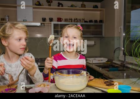 Les enfants s'amusant la préparation de muffins sucrés dans la cuisine Banque D'Images