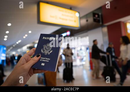 Portrait de femme tenant un passeport des États-Unis à l'aéroport. Banque D'Images