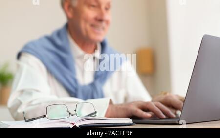 Cheerful Man working on Laptop in Office, Portrait Banque D'Images