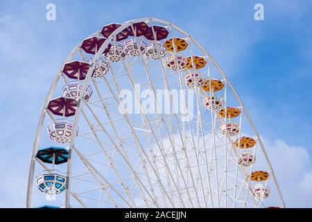 Partie supérieure de la grande roue avec différentes couleurs de gondoles, ciel bleu Banque D'Images