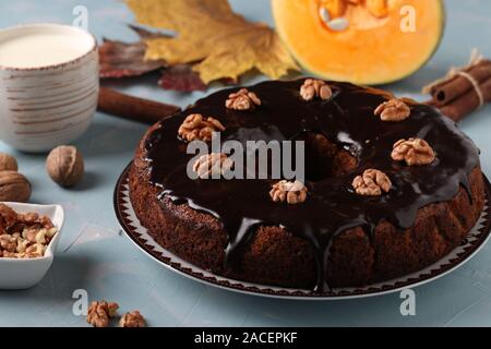 Muffin à la citrouille faits maison décorée avec glaçage au chocolat et noix sur un fond bleu clair, gros plan Banque D'Images