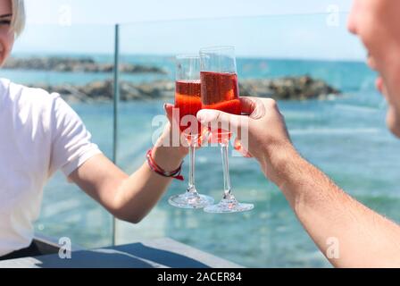 Mains de couple enjoying verres de champagne on tropical beach à sunny summer day Banque D'Images