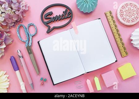 Vue de dessus télévision coucha avec diverses fournitures de bureau comme des crayons de couleur, ciseaux, bloc-notes, texte disant 'Smile' et ouvert au début de l'ordinateur portable vide f Banque D'Images