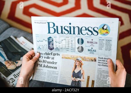 PAris, France - Aug 1, 2019 : POV Vue aérienne de femme lisant sur le canapé du salon de l'entreprise britannique Daily Telegraph supplément Banque D'Images
