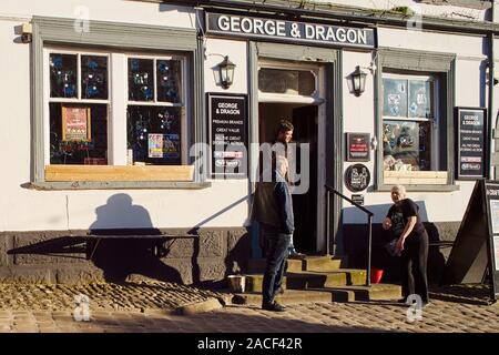 Les gens dans la conversation et fumer dehors le George & Dragon pub, Branthwaite Brow, Kendal, Cumbria, Royaume-Uni Banque D'Images