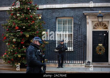 Londres, Royaume-Uni. 2 Décembre, 2019. Un agent de police armé passe devant un arbre de Noël de l'extérieur de Dartmoor 10 Downing Street. Il a été fourni par l'entreprise familiale le Dartmoor les arbres de Noël après qu'ils ont gagné le prix Champion du producteur dans le cadre d'un concours annuel. Credit : Mark Kerrison/Alamy Live News Banque D'Images