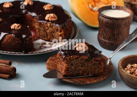 Muffin à la citrouille faits maison, avec une coupe, décoré de glaçage au chocolat et noix sur un fond bleu clair, l'orientation horizontale Banque D'Images