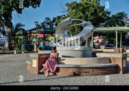 Femme assise à côté de la sculpture moderne, Cabo Rojo Plaza, Cabo Rojo, Puerto Rico Banque D'Images