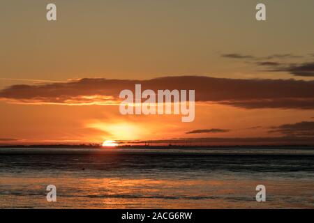 Beau coucher du soleil vu de la plage à King's Lynn dans North Norfolk, au Royaume-Uni. Banque D'Images