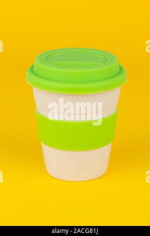Une tasse de café réutilisable tourné sur un fond jaune. Banque D'Images