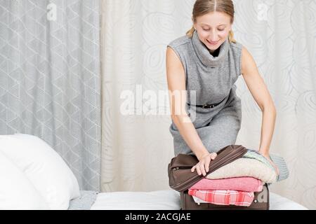 Belle femme valise d'emballage dans la chambre se préparer pour road trip. Concept de voyage Banque D'Images