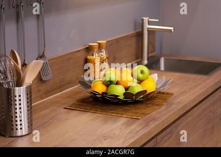 Pommes et oranges sur le comptoir de cuisine en bois. Focus sélectif. Banque D'Images