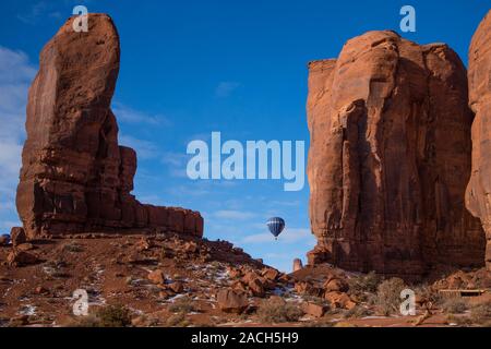 Un ballon à air chaud est perçu entre le pouce et Camel Butte dans le Monument Valley de montgolfières dans le Monument Valley Navajo Tribal Park de Arizo Banque D'Images