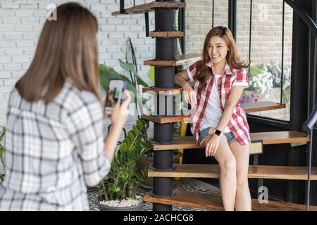 Woman taking photo de son ami avec le smartphone dans un café Banque D'Images