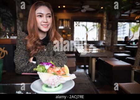 Woman eating Sashimi au saumon Salade épicée au restaurant Banque D'Images