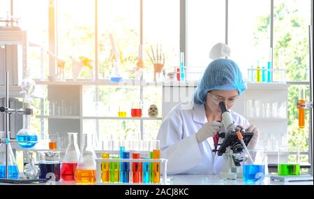 La femme scientifique faisant experiment using microscope in laboratory. Photo concept de la technologie des soins médicaux et pharmaceutiques et de la recherche Banque D'Images