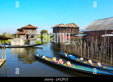 Une maison sur des tiges de bambou et des bateaux pour les touristes dans le lac Inle, Myanmar (Birmanie) Banque D'Images