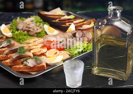 En-cas sur la table du Nouvel An. Caviar rouge, bacon sur des toasts avec de la moutarde douce, légèrement hareng salé sur du pain, champignons, saucisses faites maison. H Vodka Banque D'Images