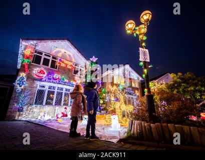 Les gens regardent l'écran Noël sur Stone Brick Lane à Rothwell, Yorkshire, comme les maisons de la rue sont éclairés par les lumières de Noël lors d'un événement qui est devenu connu comme le Stone Brick Lights. Banque D'Images