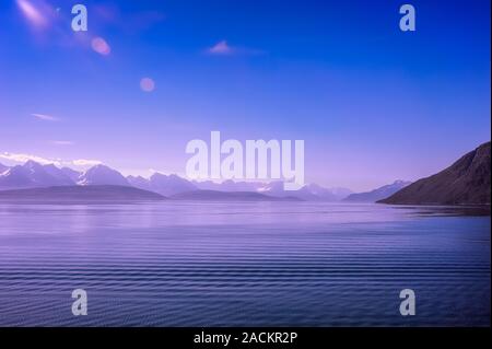 Ciel bleu paysage. Des vagues de calme et Fjord contrastent nettement avec une toile de fond les sommets enneigés des Alpes de Lyngen. Banque D'Images