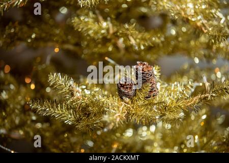 Branches d'un vert vif d'un arbre de Noël artificiel avec un cône, close-up arrière-plan. Nouveau concept de l'année Banque D'Images