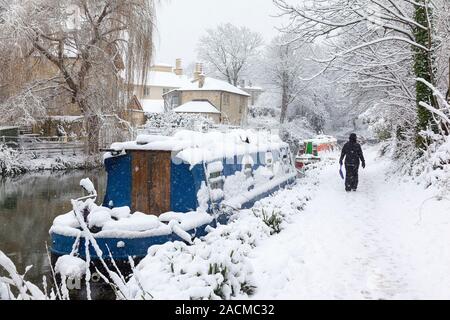 Femme marche dans l'accumulation de neige sur le chemin de halage Kennet et Avon à Bath, Angleterre, Royaume-Uni. Banque D'Images