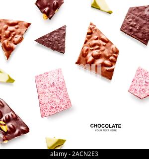 Mise en page créative avec des morceaux de chocolat. Amande, framboise et chocolat pistache arrangement motif isolé sur fond blanc. Mise à plat, haut Banque D'Images