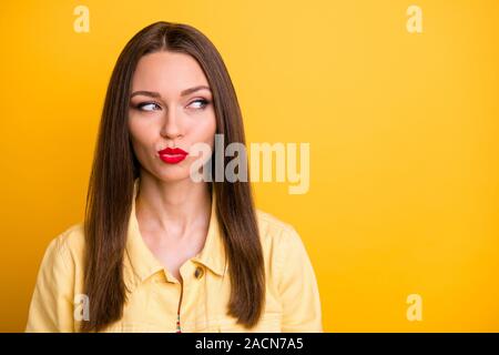 La photo en gros plan de l'intéressé cute woman à la recherche dans l'espace vide avec les lèvres à la recherche de nouvelles idées pomaded il y a un fond de couleur vive isolé Banque D'Images