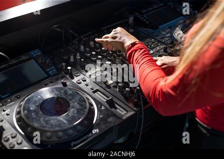 Dame Mains sur panneau DJ à jouer de la musique dans une boîte de nuit Banque D'Images