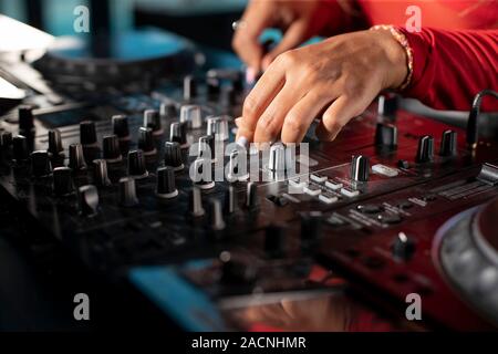 Dame Mains sur panneau DJ à jouer de la musique dans une boîte de nuit Banque D'Images