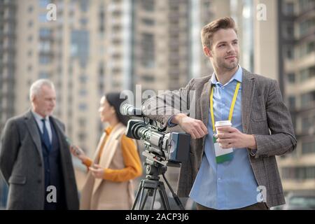 Beau jeune reporter se sentir bien pendant les pauses dans le travail Banque D'Images