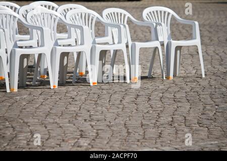 Des chaises en plastique blanc alignés Banque D'Images