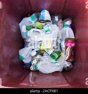 Déchets recyclables foyer : les bouteilles en plastique, boîtes de conserve en métal et verre bouteille de recyclage des déchets dans une poubelle sur roues barrée d'une marron. Banque D'Images