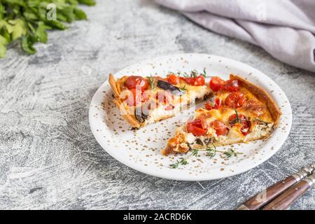 Quiche végétarienne tarte faite maison, avec des tomates cerises, aubergines et fromage feta sur un fond clair/ Banque D'Images