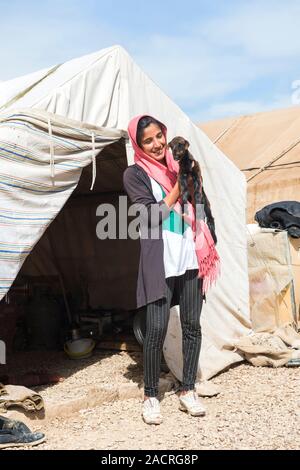 Jeune femme Qashqai avec une chèvre dans les bras, Qashqai camp nomade, la province du Fars, Iran Banque D'Images