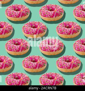 L'alimentation lumineux seamless pattern isométrique avec donuts donuts glacé.Pink sprinkles sucre coloré bleu sur fond bleu turquoise Banque D'Images