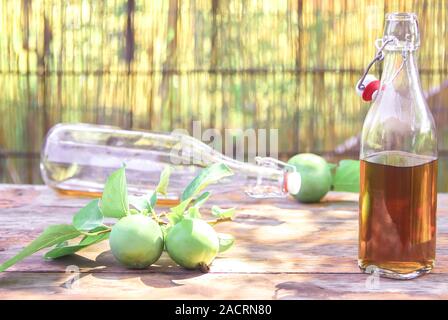 Une bouteille de cidre de pomme. Still Life, de mal dispersés demi-bouteilles vides avec le vinaigre de cidre de pomme. Composition avec des lunettes, les décorations de la cannelle Banque D'Images
