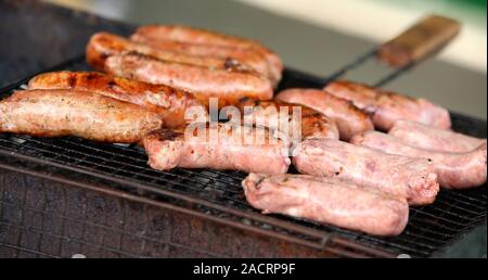 Saucisses fraîches et des hot-dogs sur le gril. Banque D'Images