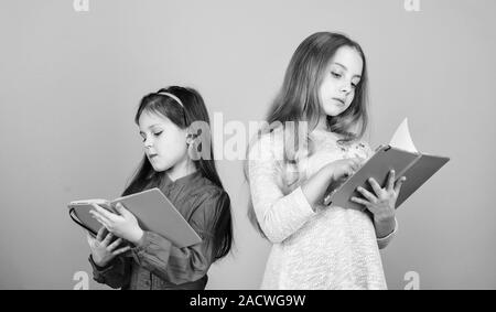 Heureux les petits enfants prêts pour l'école leçon. les élèves de lire un livre. Projet d'école. Amitié et fraternité. de cahiers d'écriture. Retour à l'école. les petites filles avec note books. La découverte de la guérison. Banque D'Images