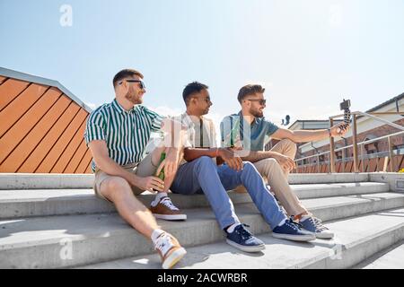 Les loisirs, la technologie et les gens heureux - concept d'amis masculins prenant en selfies smartphone sur trépied et boire de la bière sur la rue en été Banque D'Images
