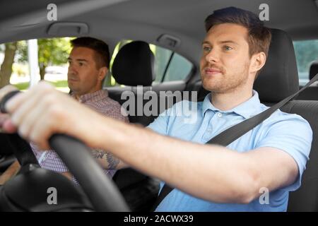 Leçon de conduite automobile et le covoiturage concept - instructeur sur le siège passager et le jeune pilote Banque D'Images